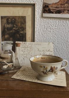 an old fashioned soup bowl sits on a table next to some papers and other items