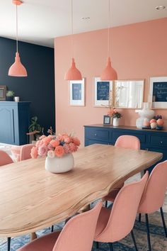 a dining room with pink chairs and a wooden table