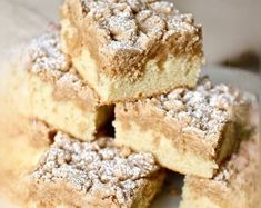 several pieces of cake sitting on top of a white plate with powdered sugar toppings