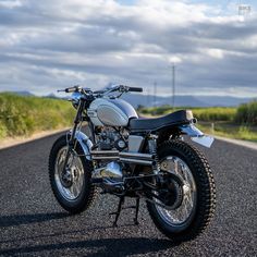 the motorcycle is parked on the side of the road in the middle of the country