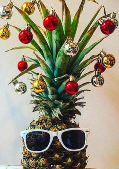 a pineapple with sunglasses and christmas ornaments on it