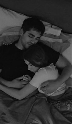 black and white photograph of two people laying in bed