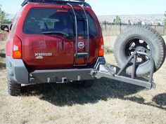 a red truck with a trailer attached to it's rear end in the grass