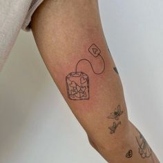 a person's arm with tattoos on it and an ice cream container in the middle