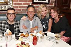 three people sitting at a table with food