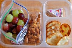 grapes, almonds, pita crackers, laughing cow cheese in a plastic container