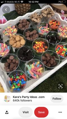 a table topped with lots of plastic cups filled with different types of candy and candies