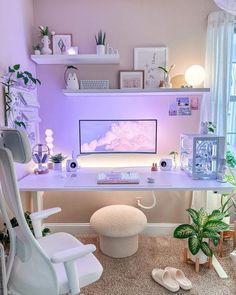 a white desk with a computer on it in a room filled with plants and other items