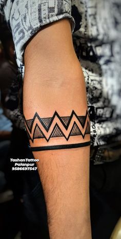 a man with a tattoo on his arm that is black and white, has an arrow in the middle