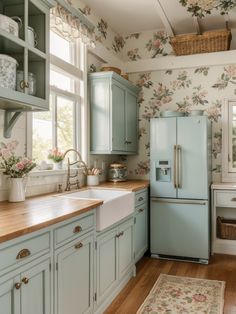 a kitchen with blue cabinets and floral wallpaper on the walls, along with a rug