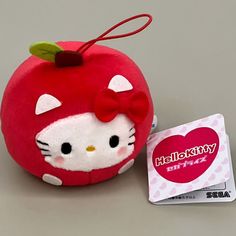 a hello kitty apple stuffed animal next to a credit card