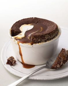 a chocolate cake in a white bowl with caramel drizzle on top