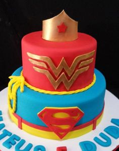 a birthday cake with a superman and wonder symbol on top