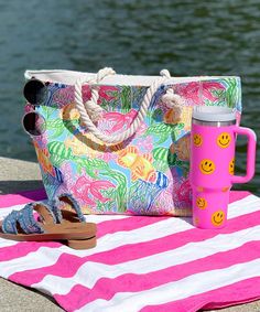 a pink and white striped towel with a handbag, flip flops, and sandals on it