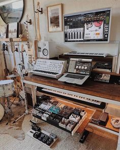 there are many musical instruments on the table in this room, including an electronic keyboard