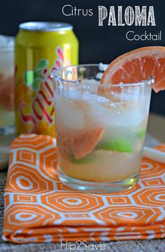 a close up of a drink in a glass with an orange slice on the rim