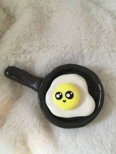 an egg in the shape of a smiley face on a black cast iron skillet