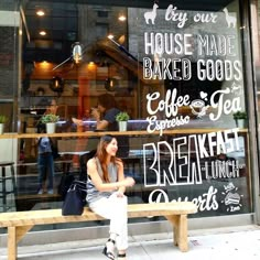 a woman sitting on a bench in front of a bakery