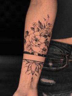 a woman's arm with a flower tattoo on it