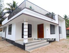 a small white house with black shutters on the front and stairs leading up to it