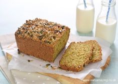 a loaf of bread sitting on top of a cutting board next to a glass of milk