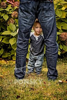 a young boy standing next to an adult