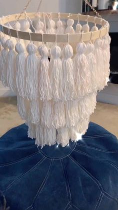 a white chandelier with tassels hanging from it's sides in a living room