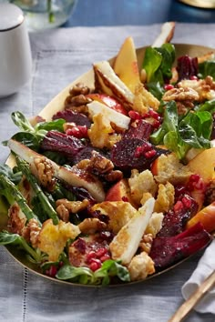 a salad with apples, cranberry sauce and walnuts in a bowl on a table