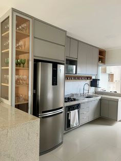 a stainless steel refrigerator freezer sitting inside of a kitchen next to a counter top