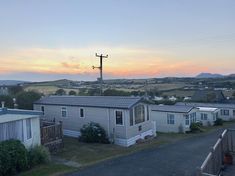 the sun is setting over some mobile homes