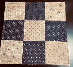 a patchwork table runner with blue and white squares on the top, along with polka dots