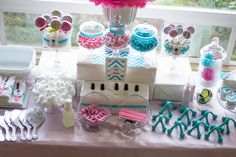 a table filled with lots of candy and desserts next to a window sill