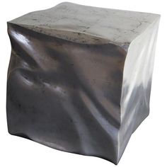 a white marble block sitting on top of a metal tablecloth covered in silver foil