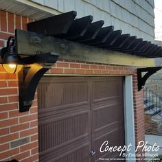 a light that is on the side of a building next to a garage door and brick wall