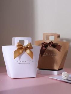 two bags with bows are sitting on a table