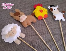 four farm animals on sticks are sitting on a table with the stick in the shape of sheep, cow and chicken