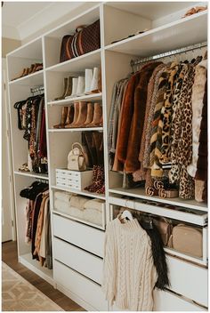 an organized closet with white shelving and lots of coats, shoes and sweaters