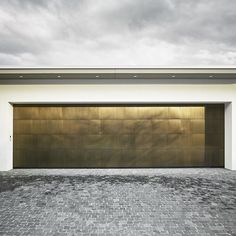 an empty garage with a brick floor and two doors on the side of the building