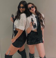 two young women dressed in black and white posing for the camera with their guitar strings