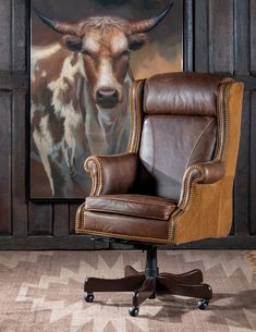 an office chair with a cow painting in the background