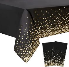 a black table cloth with gold dots on it and two matching napkins next to it