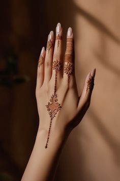 a woman's hand with henna tattoos on it