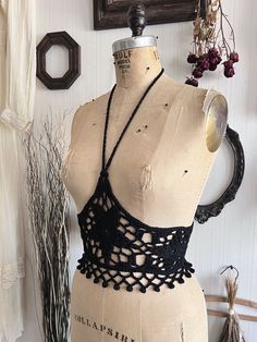 a mannequin wearing a black crochet halter top