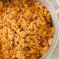 a casserole dish with rice and vegetables in it on a blue table cloth