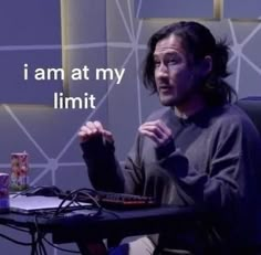 a man sitting in front of a computer desk with the words i am at my limit