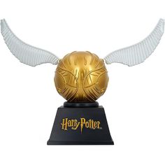 a golden harry potter ball with wings on top of a black base and white wings