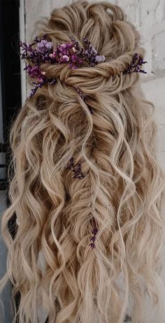 a woman with long blonde hair and purple flowers in her hair