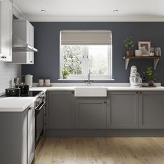 a kitchen with gray cabinets and white counter tops