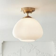 a white ceiling light hanging from the ceiling in a living room or dining room area