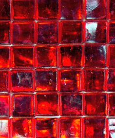 a close up shot of red glass tiles